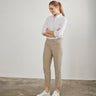 Model i beige bukser fra Cero med lige ben og 7/8-længde, stylet med hvid skjorte og hvide sneakers, set forfra