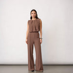 Model i brun jumpsuit i Walnut med draperet overdel og lange vide ben, fuld figur forfra