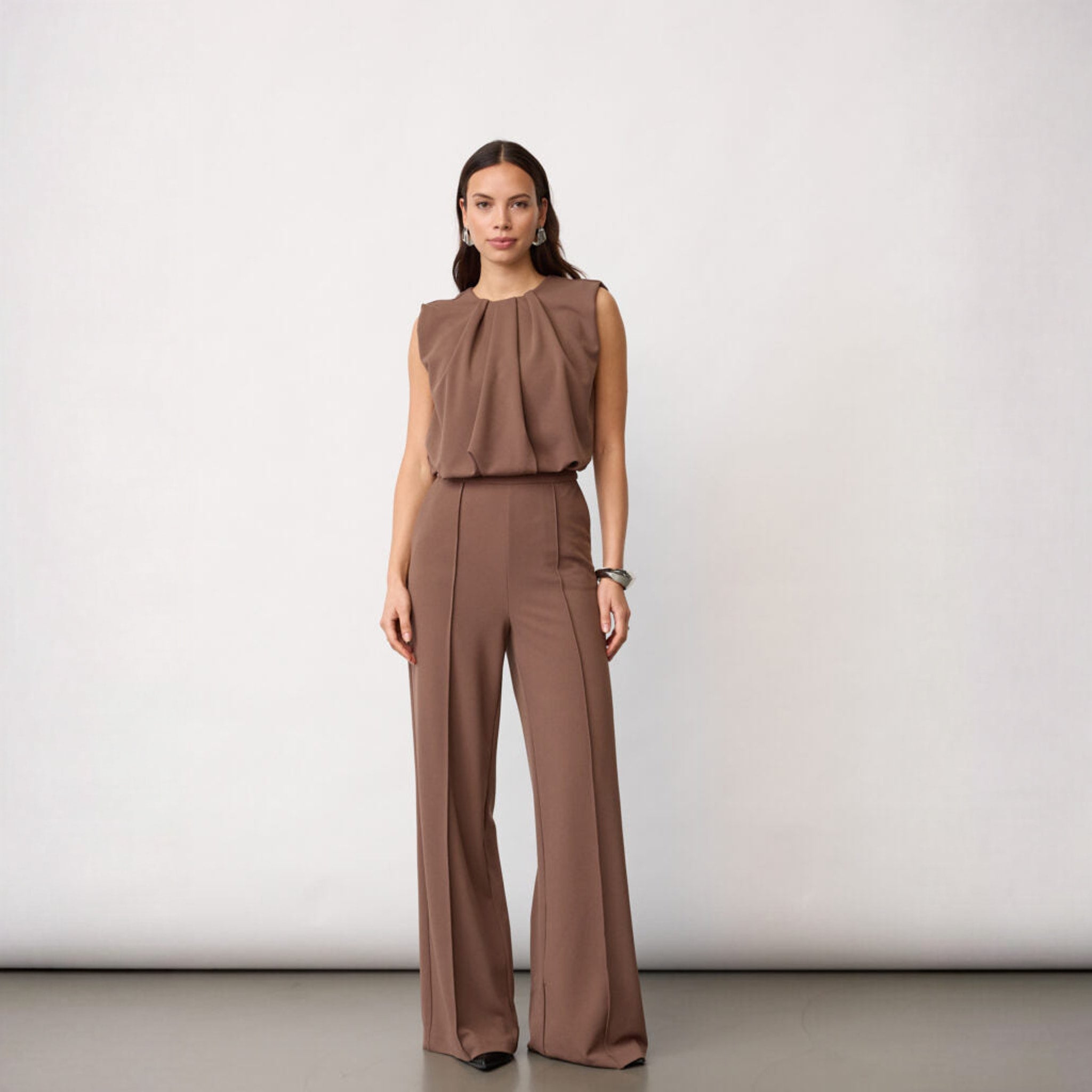 Model i brun jumpsuit i Walnut med draperet overdel og lange vide ben, fuld figur forfra