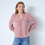 Pink skjorte med blondebånd, V-hals og puffede skuldre set forfra på model i jeans