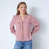 Pink skjorte med blondebånd, V-hals og puffede skuldre set forfra på model i jeans