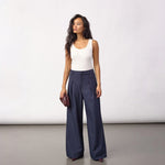 Model i navy wide leg bukser med læg foran og hvid top set forfra