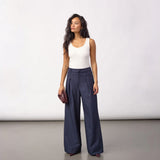 Model i navy wide leg bukser med læg foran og hvid top set forfra