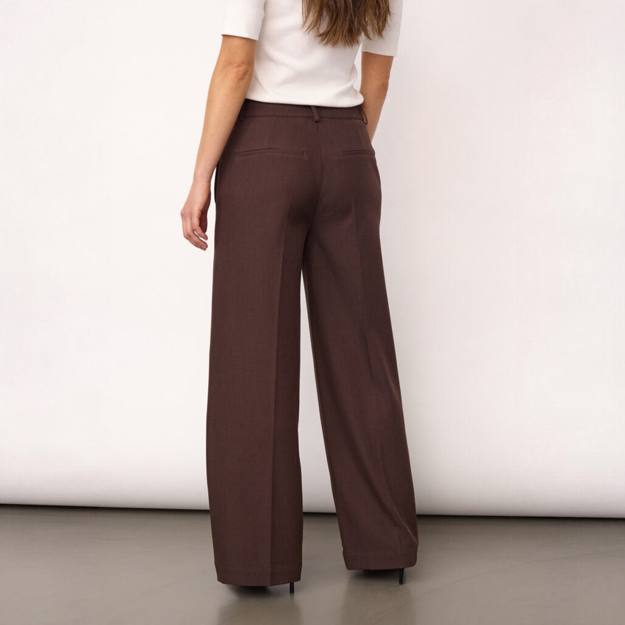 Model set bagfra i brune wide leg bukser med pressefolder
