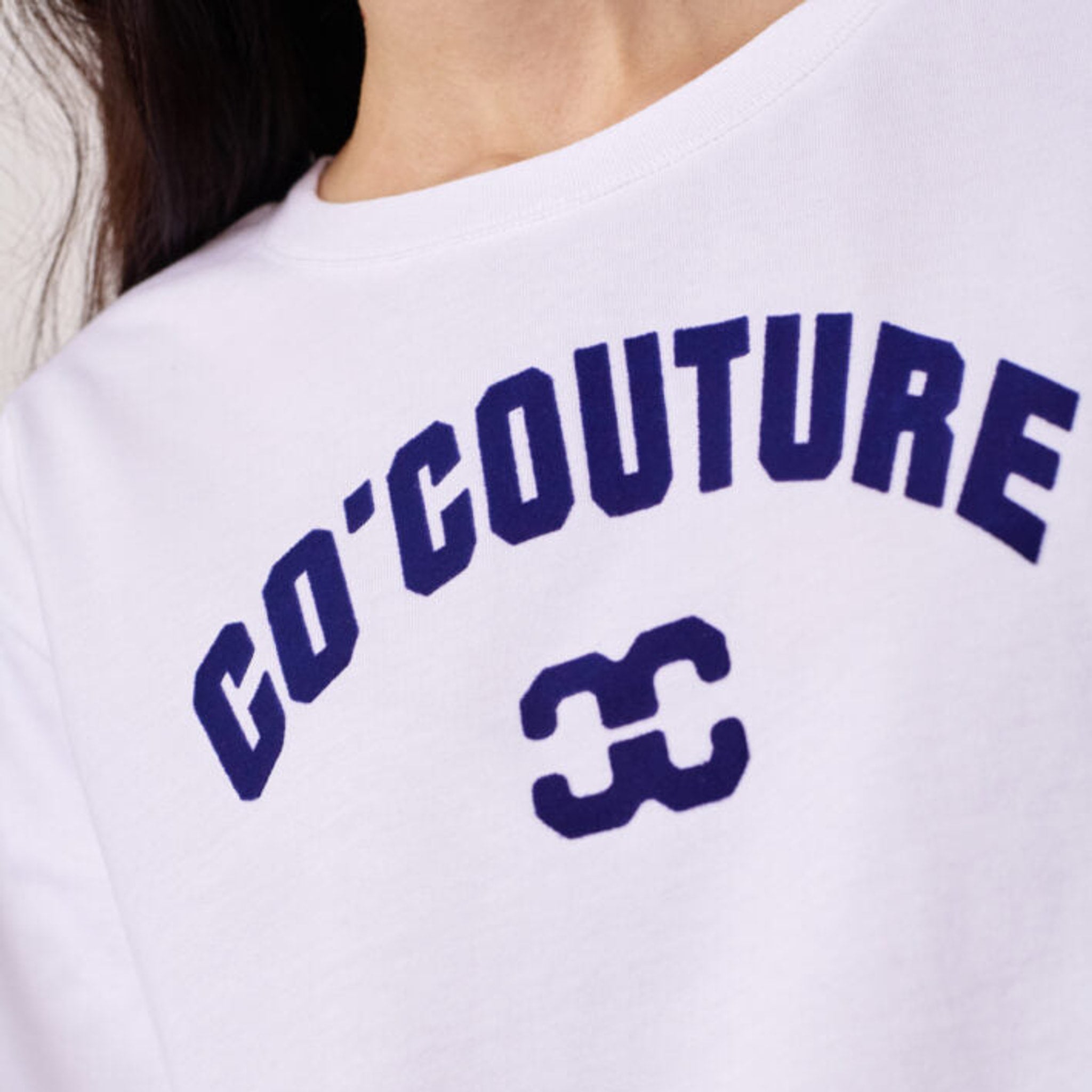 Nærbillede af navy Co'Couture-logo og CC-logo på hvid t-shirt