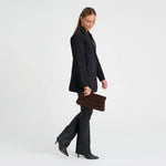 Model holder brun taske i ruskind til sort blazer og sorte bukser, set fra siden