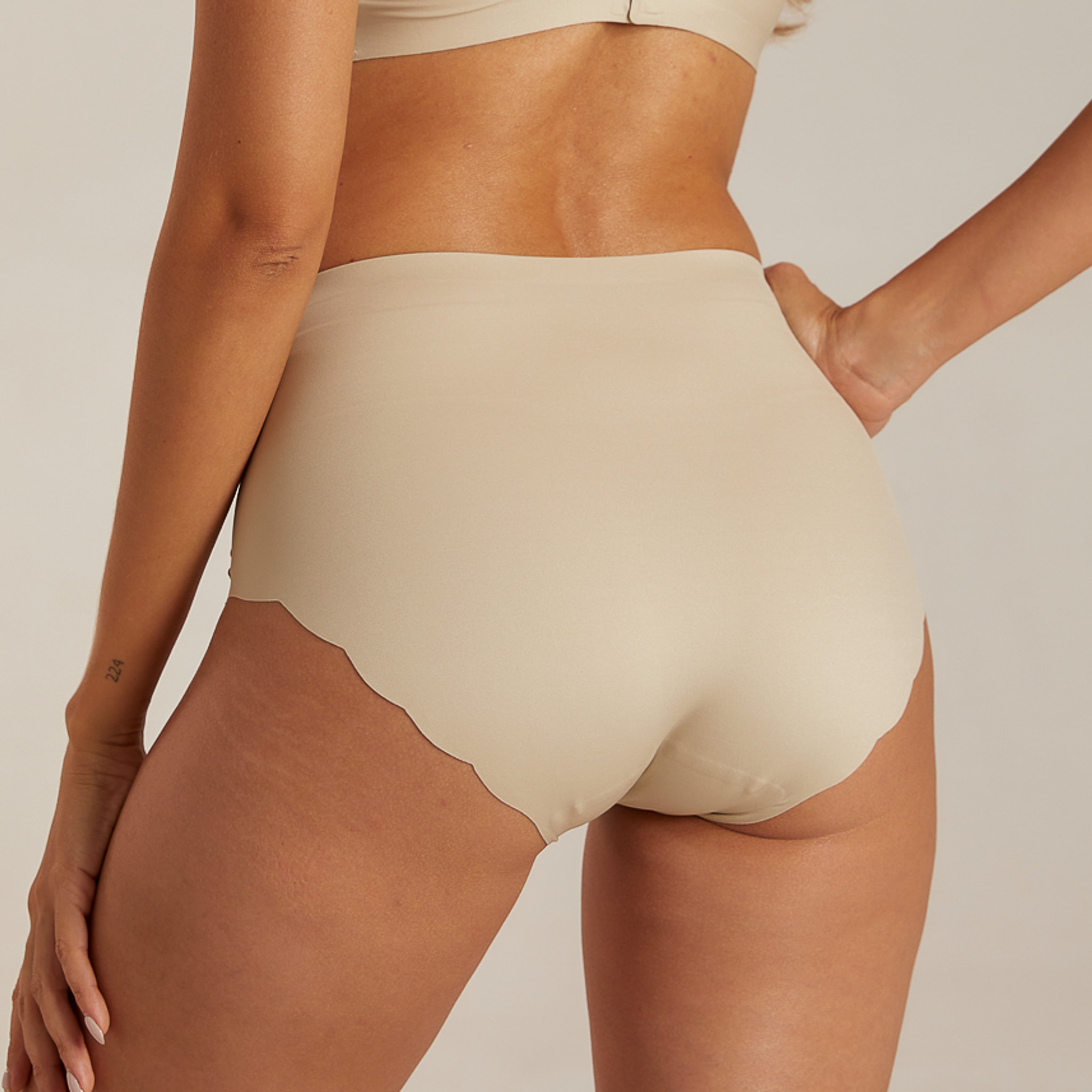 Beige highwaist trusse i Sand fra Femifemme set bagfra med fuld dækning og bølget kant ved benene