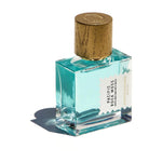 Pacific Rock Moss parfume fra Goldfield & Banks i firkantet glasflaske med lyseblå væske og låg med træstruktur, stående