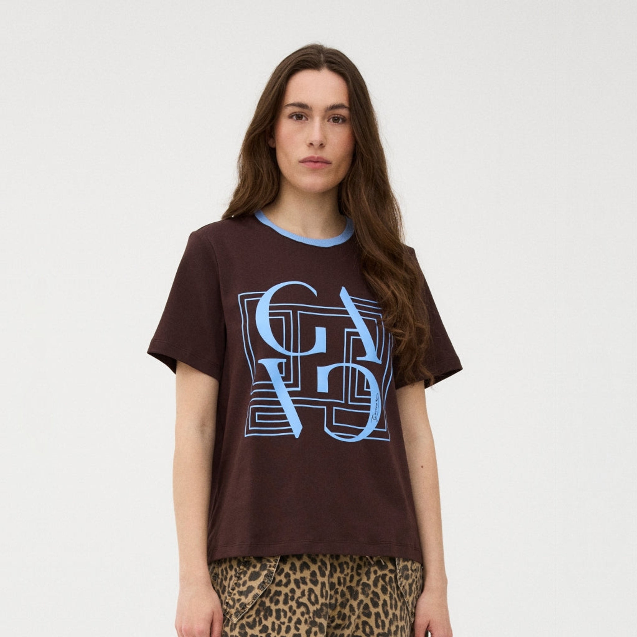 Model i brun Gossia Bas Tee t-shirt med blåt grafisk print foran