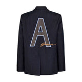 Navy blazer med nålestriber set bagfra med stort ternet A-motiv og orange Gossia-skrift på ryggen