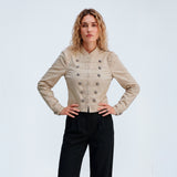 Model med hænderne i siden i beige Kelly Jacket fra Gossia og sorte bukser med læg