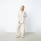 Model i beige dobbeltradet blazer fra Gossia i farven Sand stylet med lyse vide bukser