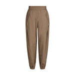 Brune Mollie bukser fra Gossia i Dark Camel set forfra med bred elastik i taljen, skrå lommer og elastik ved anklen