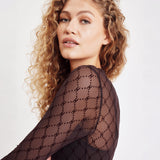 Model i brun gennemsigtig mesh bluse, nærbillede af skulder og ærme med H-monogram