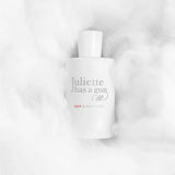 Hvid parfumeflaske Not A Perfume fra Juliette Has a Gun liggende i hvide, bløde fibre