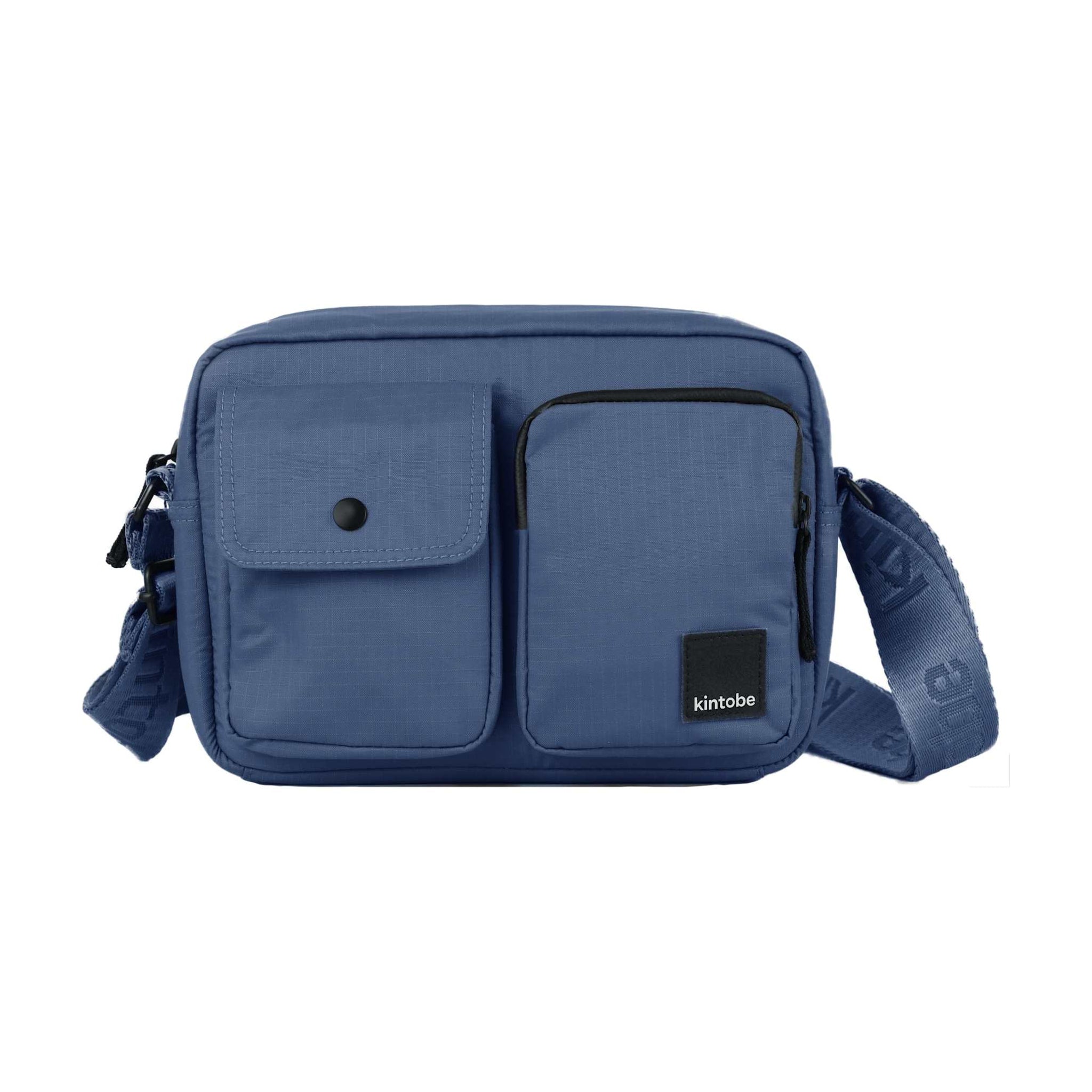 Blå crossbody-taske Miles fra Kintobe i Storm Blue set forfra med to forlommer og bred rem med logo