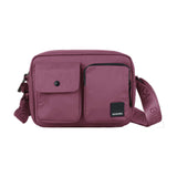 Rød Kintobe Miles crossbody-taske i Forest Berry set forfra med to lommer foran og bred skulderrem med logo