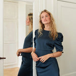 Model i navy Benua bluse ved et spejl, set let fra siden med puffede ærmer
