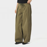 Model i grønne wide leg bukser fra Neo Noir med sort top og sorte ballerinaer