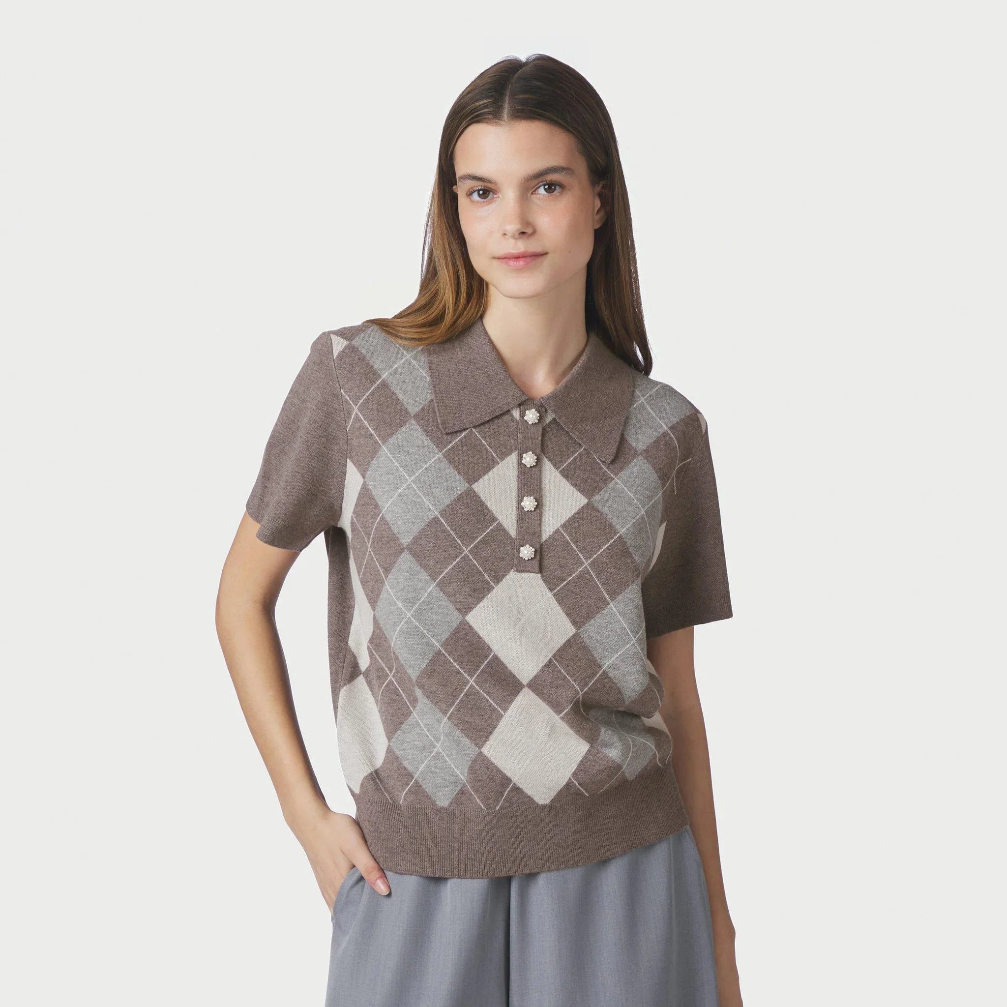 Model i brun ternet bluse i strik med polokrave og perleknapper set forfra