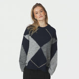 Model i oversize navy strik med argyle mønster og lange vide ærmer, tæt på forfra