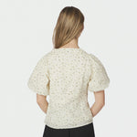 Model i lysegul blomstret bluse med puffede ærmer set bagfra