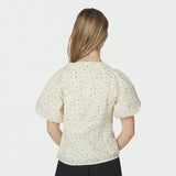 Model i lysegul blomstret bluse med puffede ærmer set bagfra