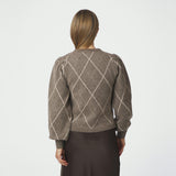 Model i beige ternet cardigan med puf ved skulderen, set bagfra