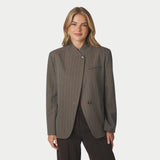 Model i brun pinstripe blazer med opstående krave og asymmetrisk lukning, tæt på forfra