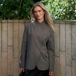 Model udendørs i brun pinstripe blazer fra Neo Noir stylet med sort nederdel