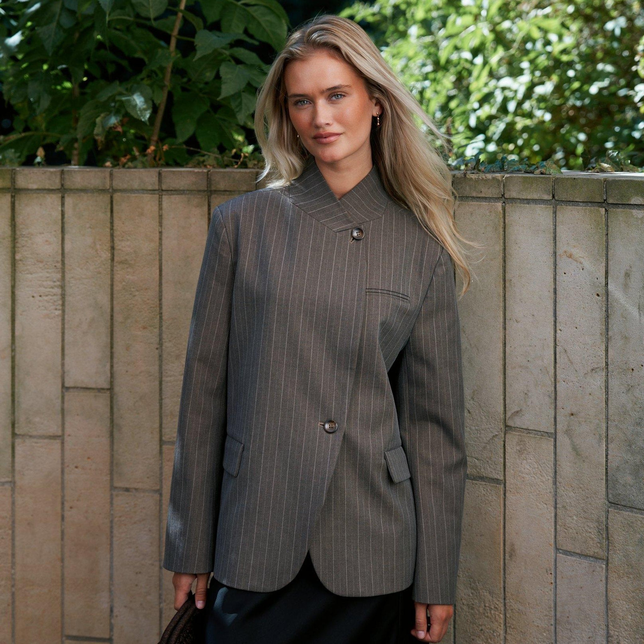 Model udendørs i brun pinstripe blazer fra Neo Noir stylet med sort nederdel