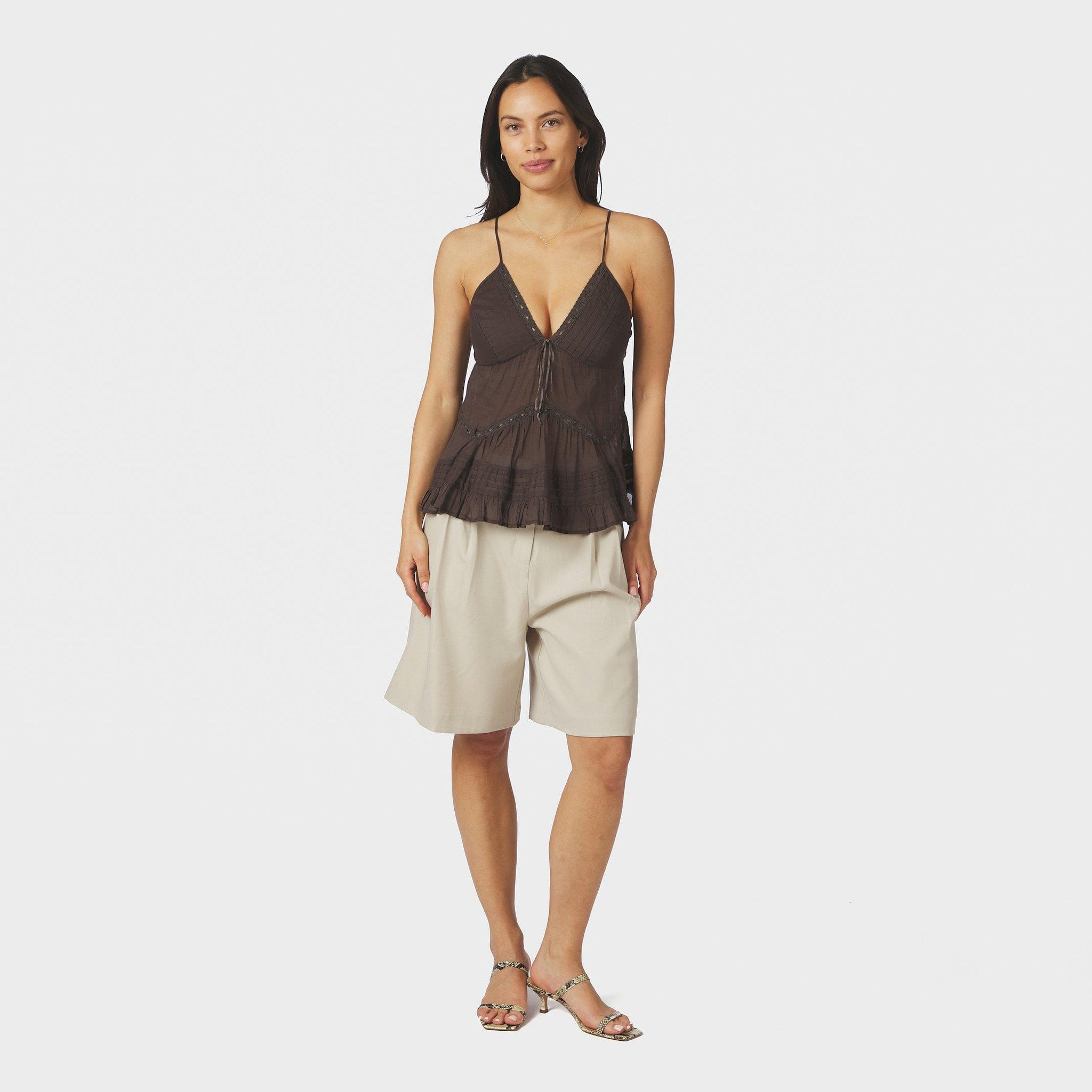 Model i fuld figur i hvide Nika Structure Shorts i Creme med brun top