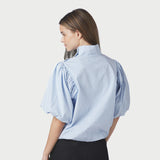 Model i blå stribet bluse set bagfra med opstående krave og pufærmer