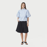 Model i blå stribet bluse med pufærmer stylet med sorte shorts og sorte sandaler med hæl