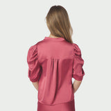 Model i pink satinbluse Roella set bagfra med puffede ærmer og bærestykke