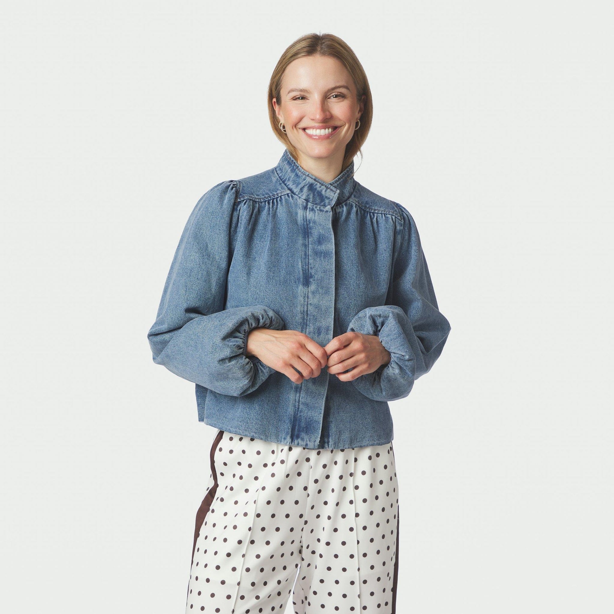 Model i blå denimjakke med høj hals og pufærmer set forfra