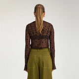 Model i brun mesh t-shirt med sorte prikker set bagfra