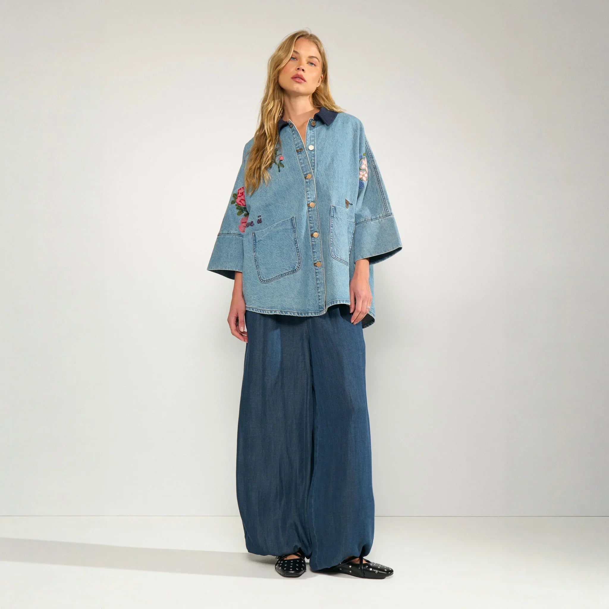 Model i hel figur i mørkeblå parachute bukser fra Nümph stylet med lys denimskjorte
