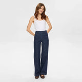 Smilende model i blå wide leg jeans med høj talje fra Nümph og hvid top set forfra