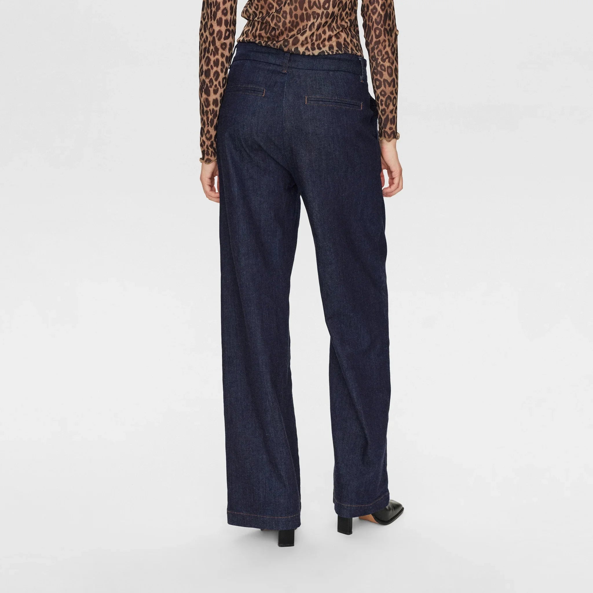 Blå wide leg bukser i denim set bagfra på model med lommer bagpå