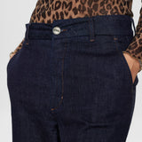 Nærbillede af knap, gylp og sidelomme på blå wide leg bukser i denim