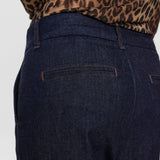 Nærbillede af lomme bagpå og brune syninger på blå wide leg bukser i denim