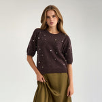 Model i brun strik med perler og puffede korte ærmer, set forfra