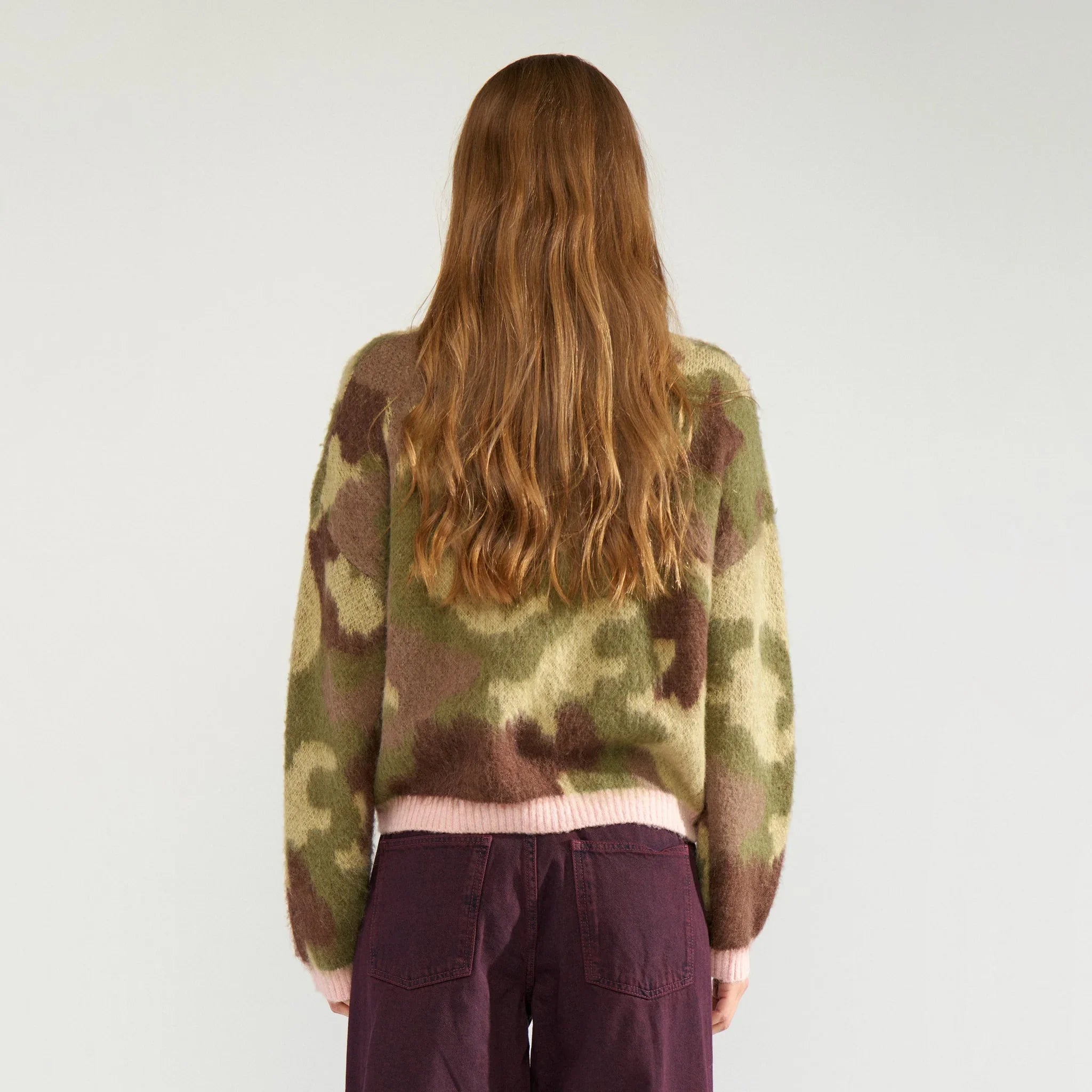 Model i grøn camouflage pullover set bagfra med lyserød ribkant ved taljen