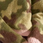 Detalje af lyserøde ribkanter ved ærmer og forneden på grøn camouflage pullover