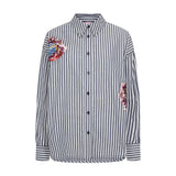 Stribet oversize skjorte i navy og hvid med broderede blomster og pailletter, set forfra
