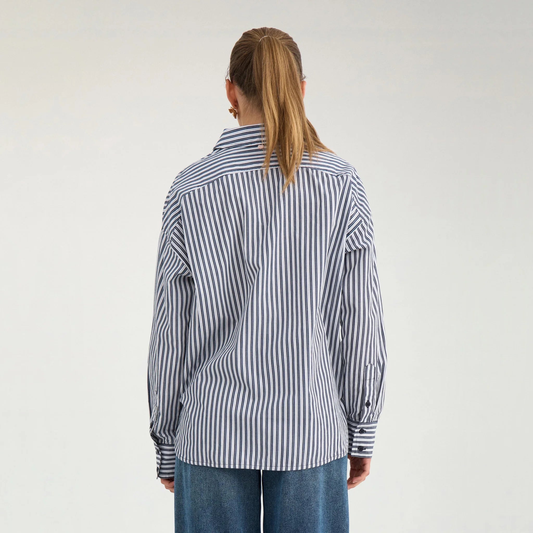Model set bagfra i stribet oversize skjorte i navy og hvid