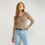 Model i brun stribet pullover med lyserød halsrib stylet med lyse jeans og brunt bælte