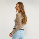 Model i brun stribet pullover set fra siden og bagfra med lyse jeans