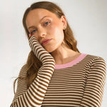 Tæt nærbillede af ribstrikkede brune og creme striber og lyserød rund hals på pullover